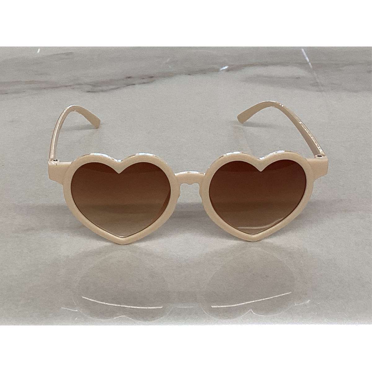 Heart sunglasses in sand